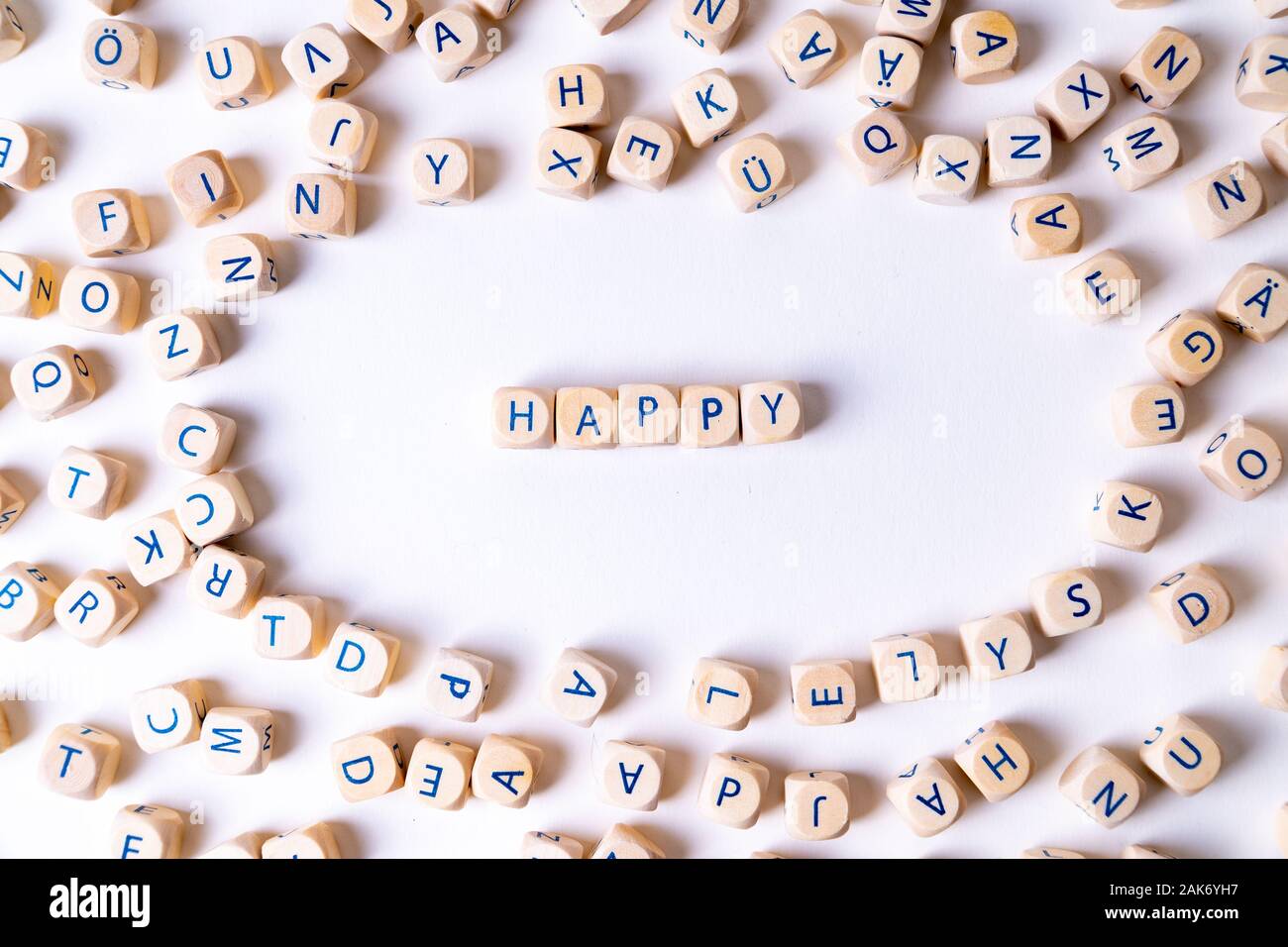 Würfel mit Buchstaben das Wort 'glücklich' in der Mitte der gelegentlichen Würfel um Festlegung Stockfoto