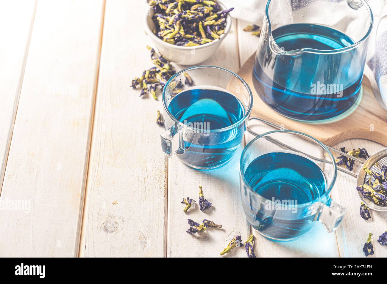 Blauer Tee in Glas-Tassen und Glas Teekanne, weißem Holz Hintergrund Stockfoto