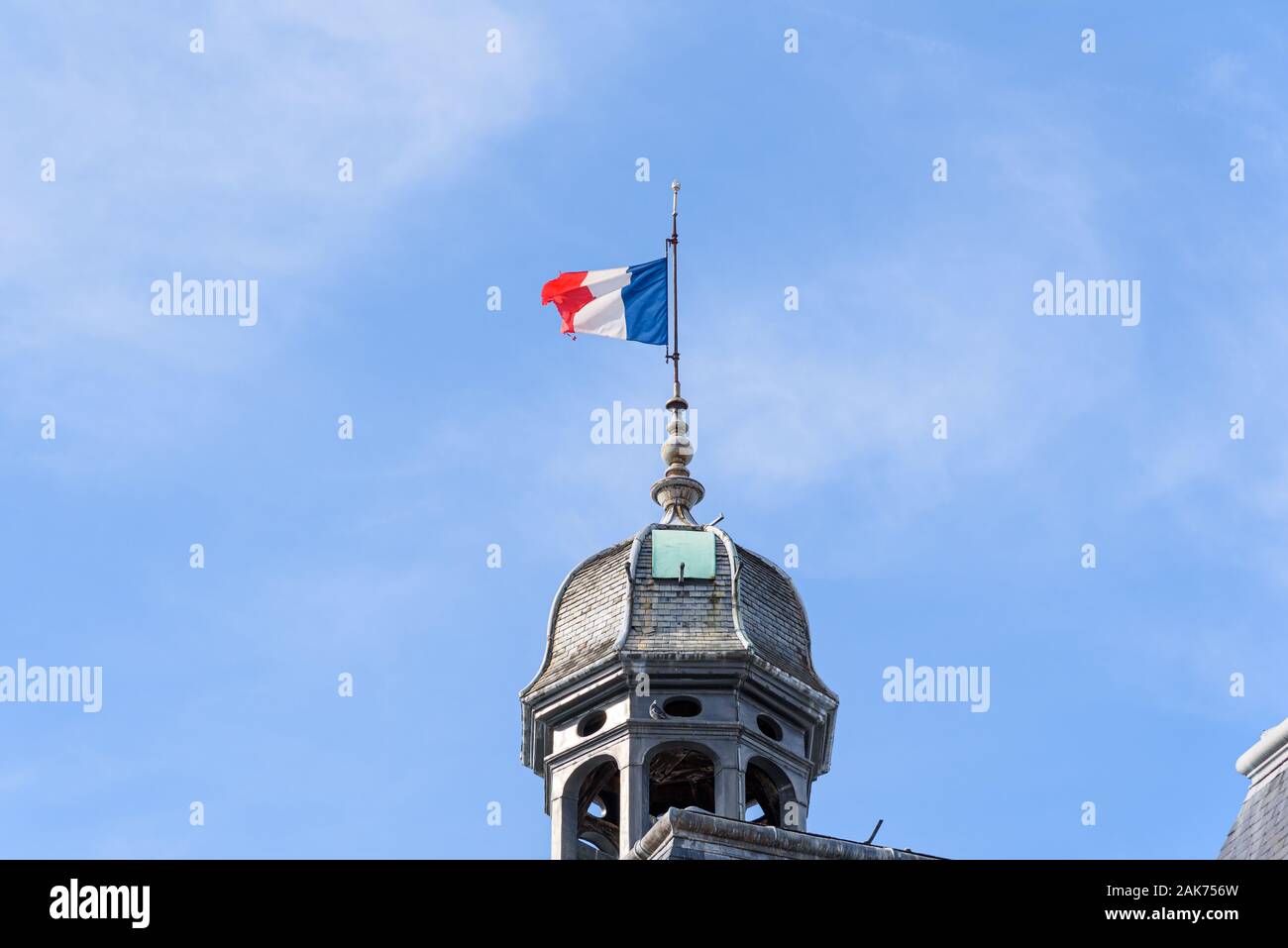 Französische nationale Flagge an einem Mast auf einem alten Dome, vor blauem Himmel Stockfoto