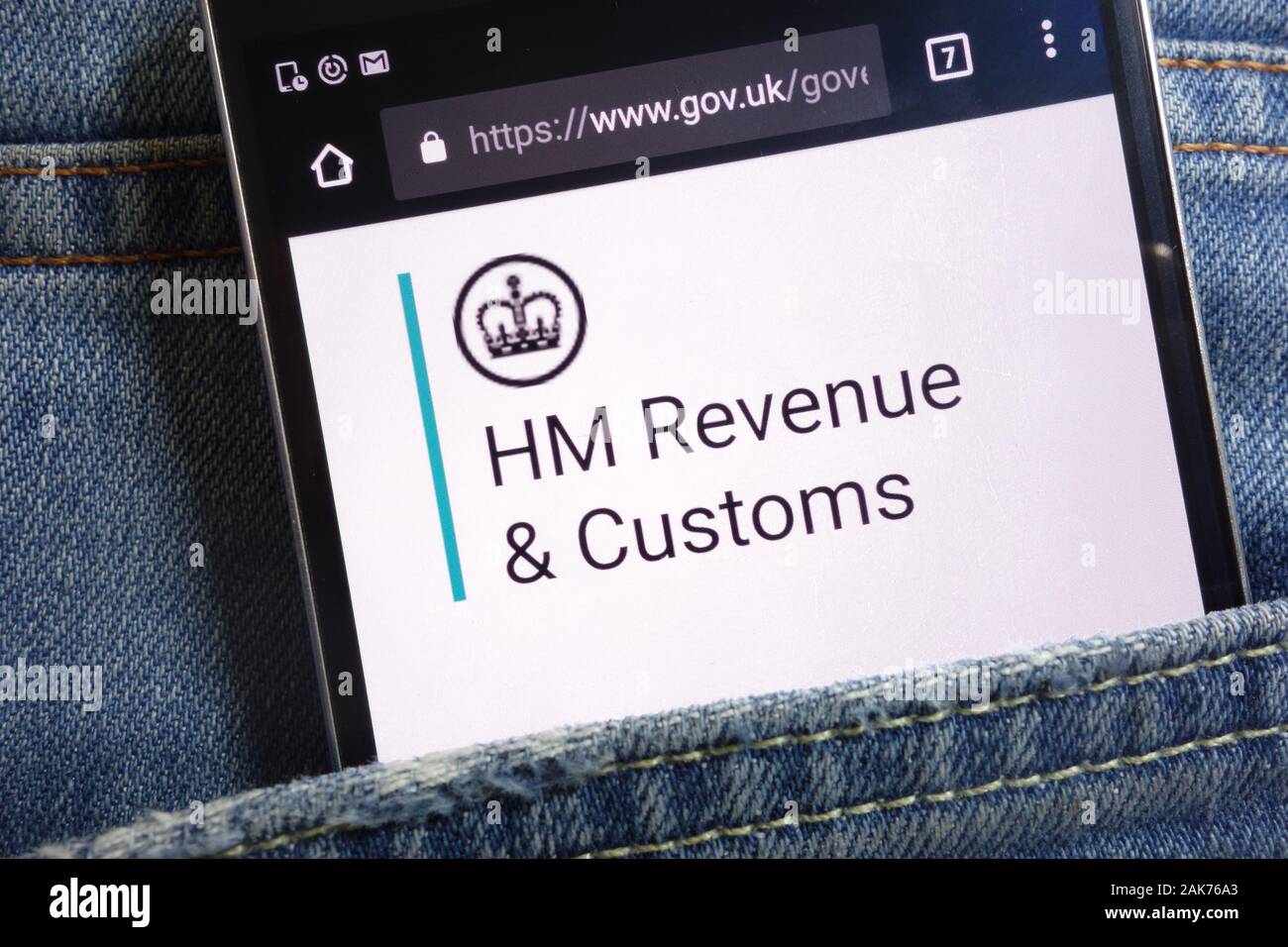 Die Regierung des Vereinigten Königreichs website für HM Einnahmen und Zoll auf dem Smartphone in Jeans Tasche versteckt angezeigt Stockfoto