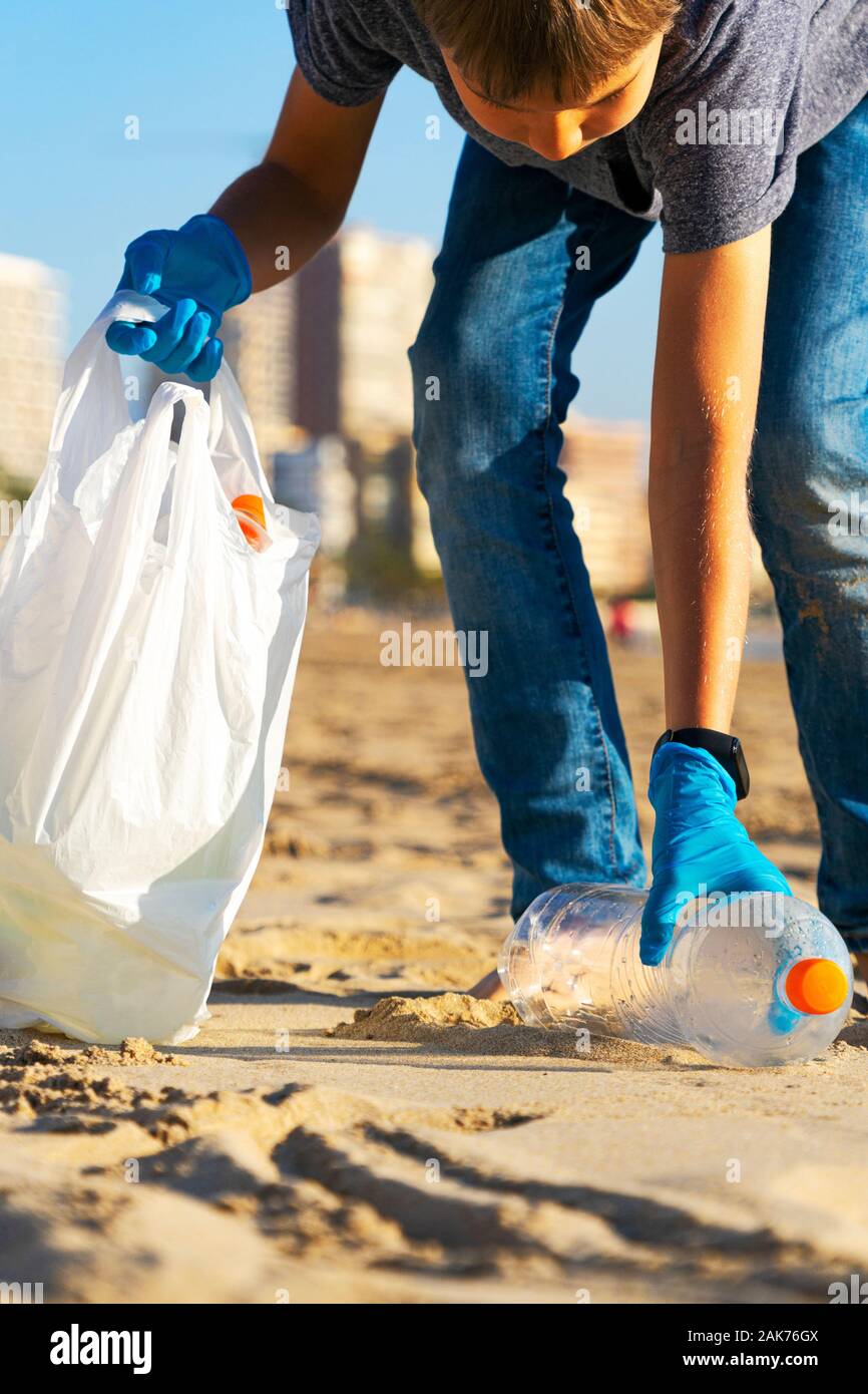 Reinigung Stadt Strand aus Kunststoff Papierkorb. Kid Abholung Plastikflasche Papierkorb vom Strand und in Plastikbeutel für Recycling Stockfoto