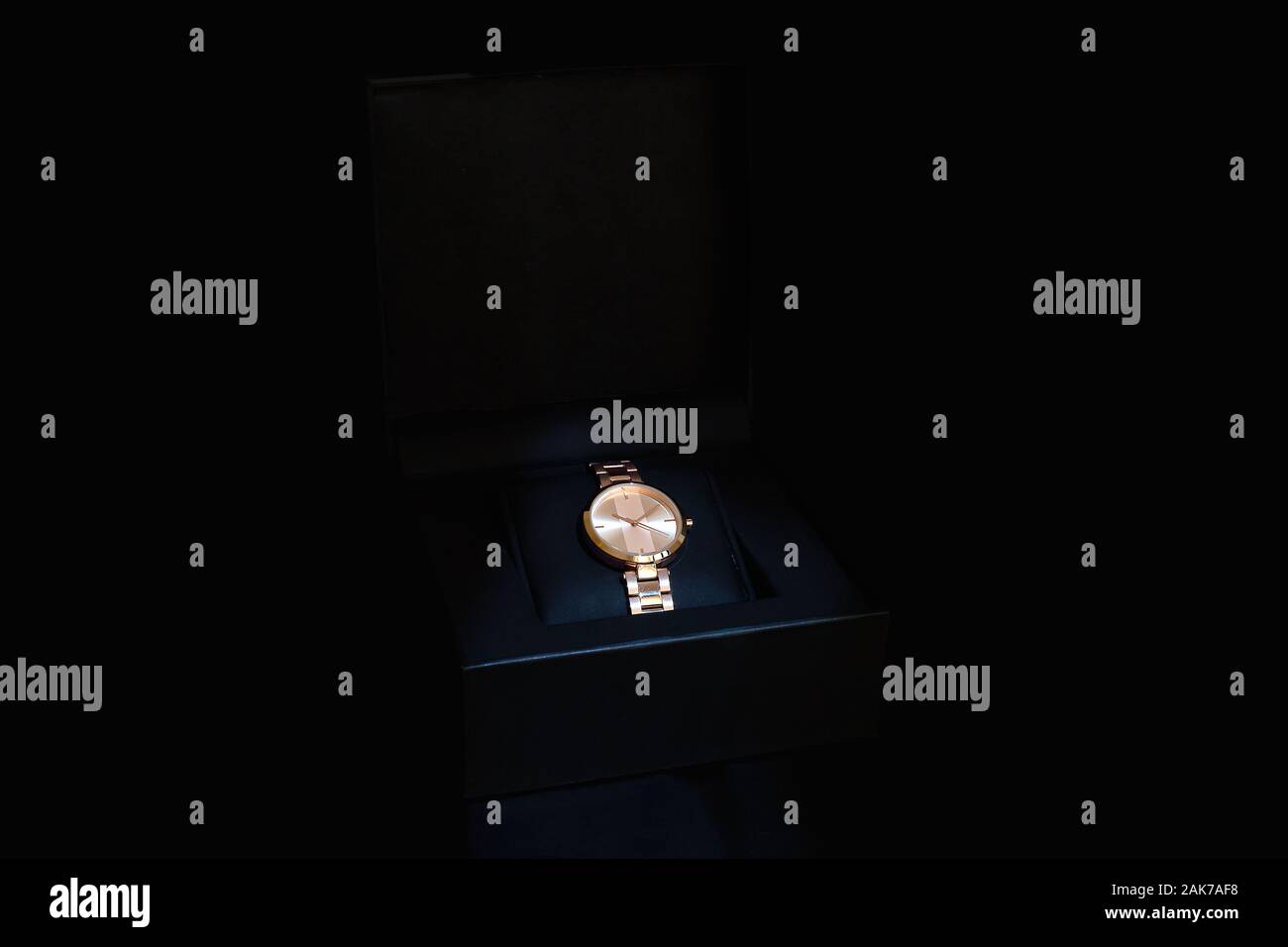 Männer Golden gefärbt, klassische runde Armbanduhr mit Metallband in einem offenen "black box". Auf schwarzem Hintergrund isoliert. Stockfoto