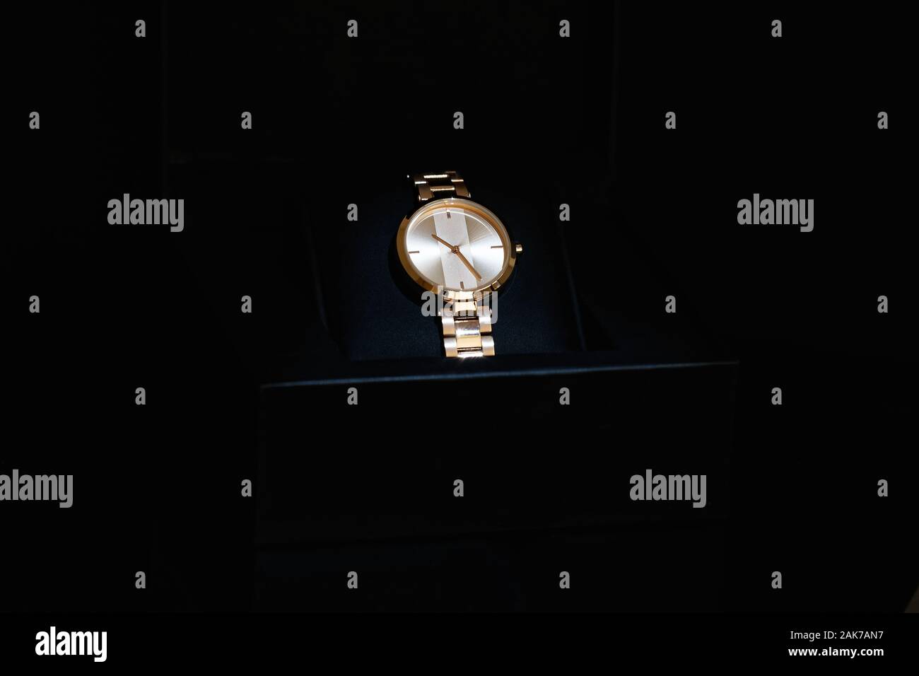 Männer Golden gefärbt, klassische runde Armbanduhr mit Metallband in einem offenen "black box". Auf schwarzem Hintergrund isoliert. Stockfoto