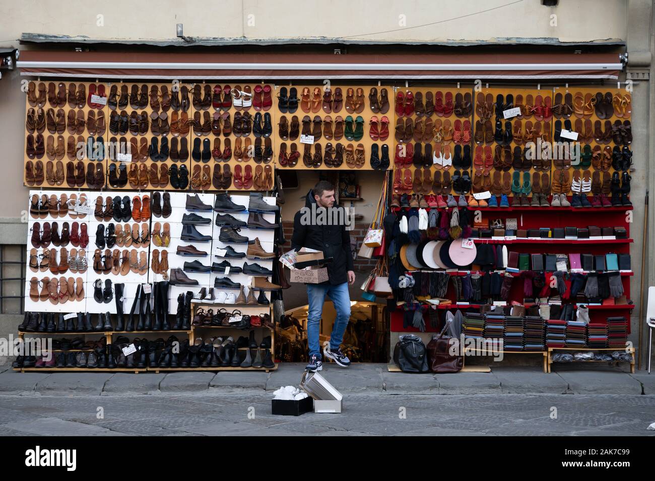 Ein Mann vor einem Schaufenster für den Verkauf von Lederwaren in Florenz, Italien. Stockfoto