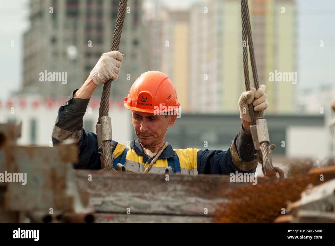 Erbauer in Uniform und Helm mit Kran Stockfoto