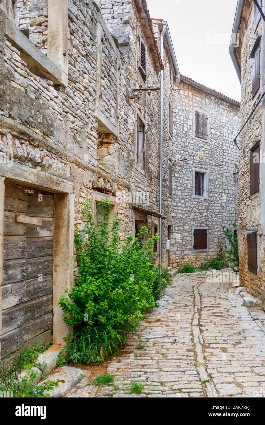 Eine gepflasterte Gasse zwischen alten Gebäuden in der historischen Altstadt in Ballen, einer kleinen Stadt auf dem Mont Perin in der Gespanschaft Istrien, Kroatien Stockfoto