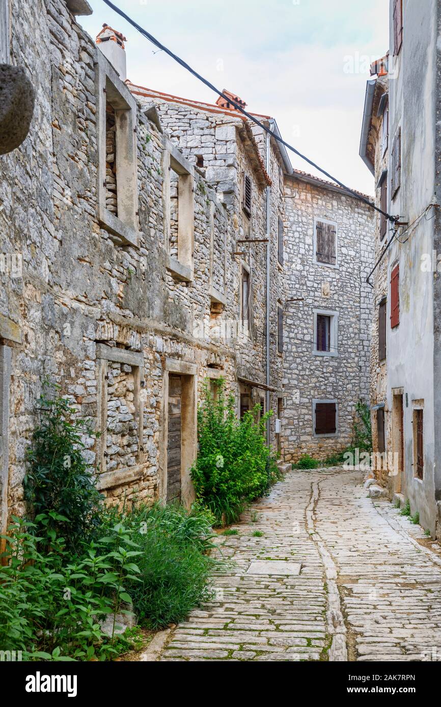 Eine gepflasterte Gasse zwischen alten Gebäuden in der historischen Altstadt in Ballen, einer kleinen Stadt auf dem Mont Perin in der Gespanschaft Istrien, Kroatien Stockfoto