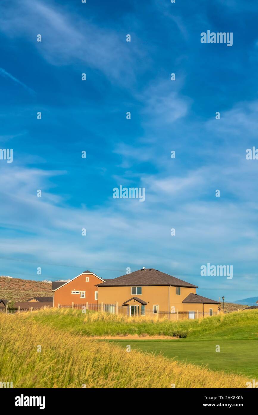 Grüne Gräser der Golfplatz mit Häuser und den Berg im malerischen Hintergrund Stockfoto