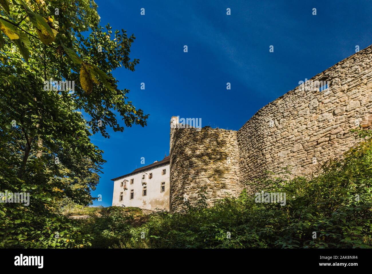 Landstein, Tschechische Republik - 29. September 2019: Mauer aus Stein und ein Gebäude einer mittelalterlichen Burg auf einem Hügel mit grünen Bäumen. Stockfoto