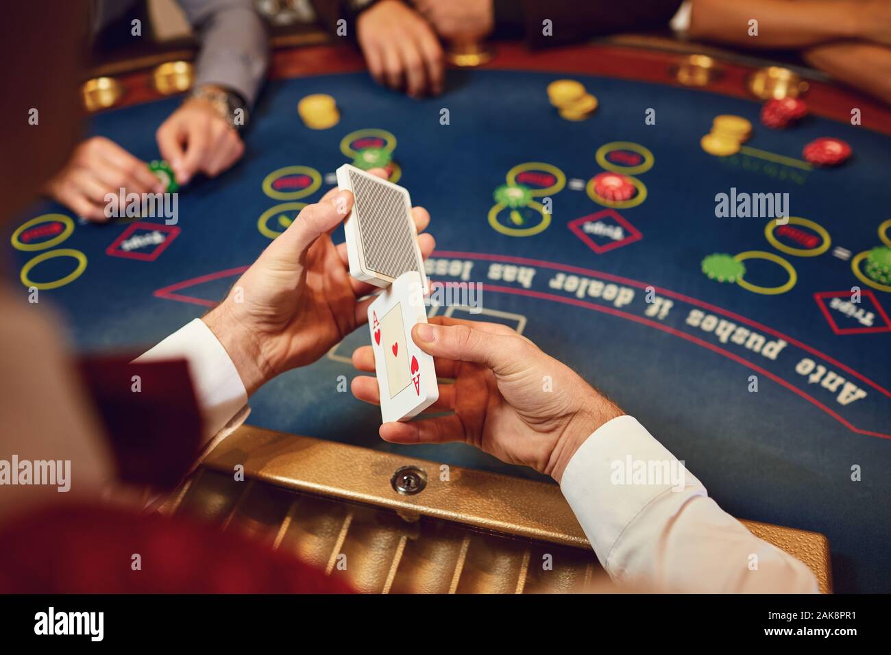 Der Croupier Poker Karten hält in seinen Händen an einem Tisch in einem Casino. Stockfoto