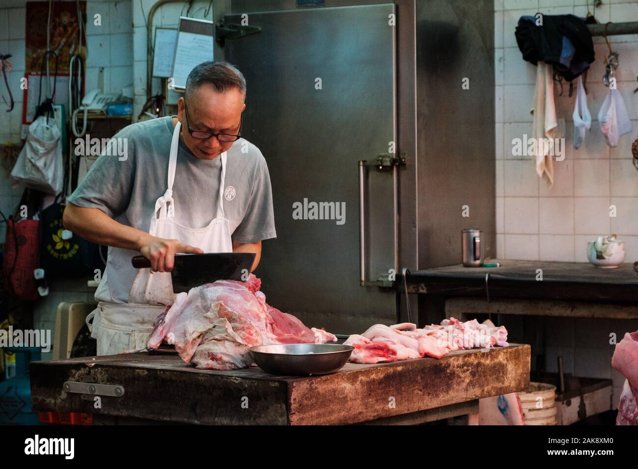 HongKong, China - November, 2019: Metzger schneidet Fleisch Metzgerei in Hongkong Stockfoto