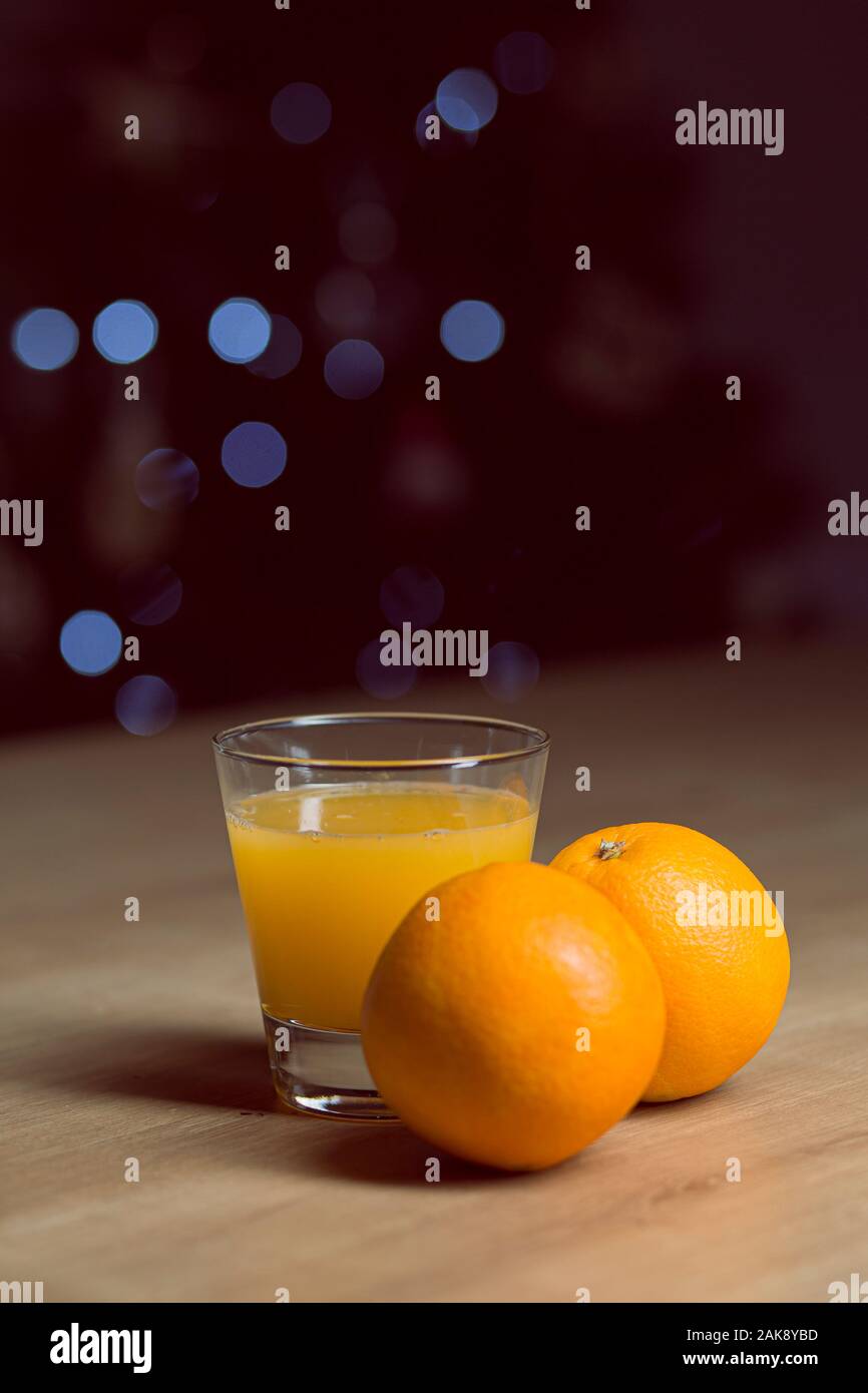 Orangensaft auf ein Trinkglas mit frischen Orangen Obst auf einem Holztisch Stockfoto