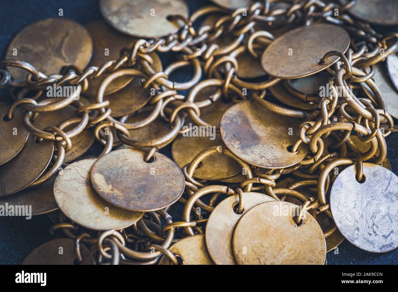 Nahaufnahme eines Armbands im Boho-Stil mit goldenen kreisförmigen kleinen Scheiben. Stockfoto