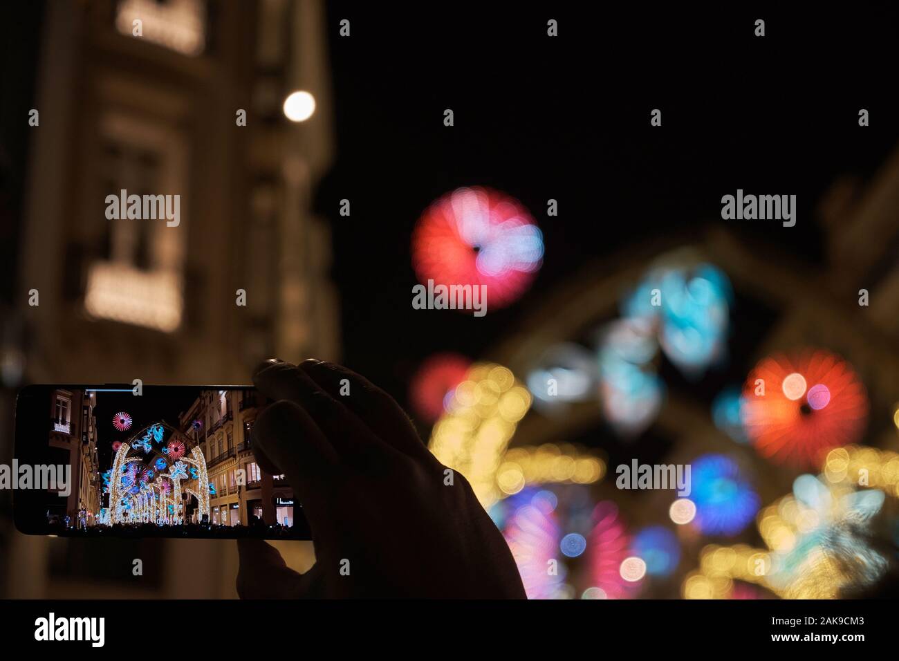 Mit einem Smartphone von Málaga Weihnachten Beleuchtung. Andalusien, Spanien. Stockfoto