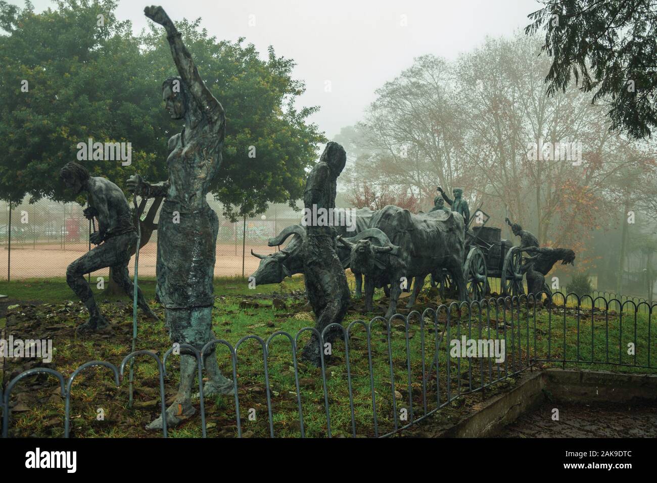 Bronze Statuen von Menschen und Ochsenkarren auf der Immigrant Denkmal in einer nebligen Tag in Bento Goncalves. Ein Wein produzierenden Land Stadt im Süden Brasiliens. Stockfoto