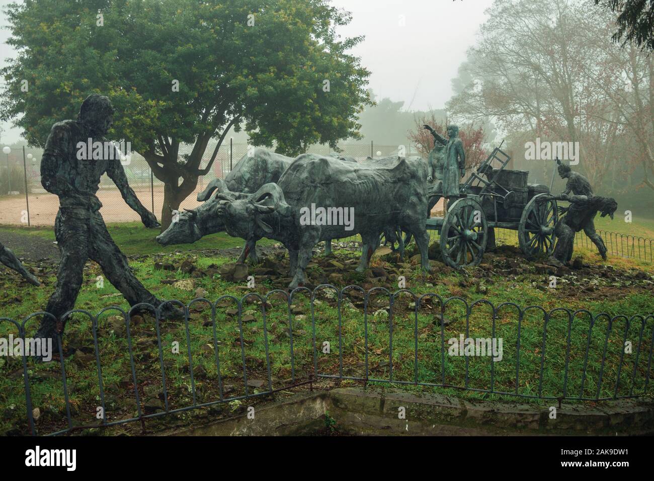 Bronze Statuen von Menschen und Ochsenkarren auf der Immigrant Denkmal in einer nebligen Tag in Bento Goncalves. Ein Wein produzierenden Land Stadt im Süden Brasiliens. Stockfoto