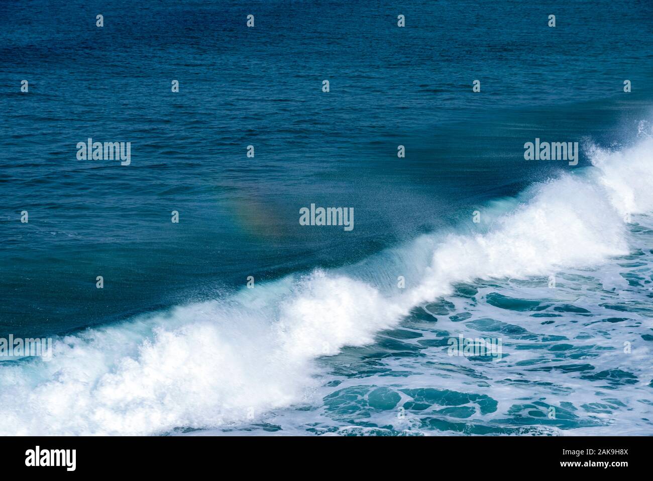 Wellen mit Spritzern und einen Regenbogen Stockfoto