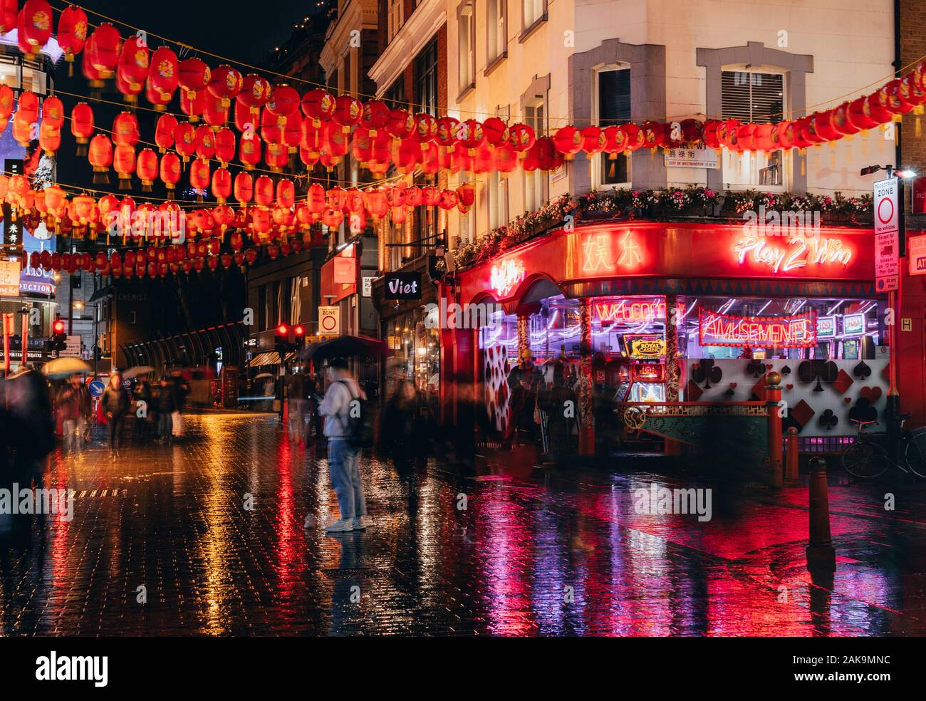 London, Großbritannien/Europa; 20/12/2019: Nacht Blick auf Chinatown Straße mit roten Lampions, Leuchtreklame und nassen Boden im Stadtteil Soho in London. Stockfoto