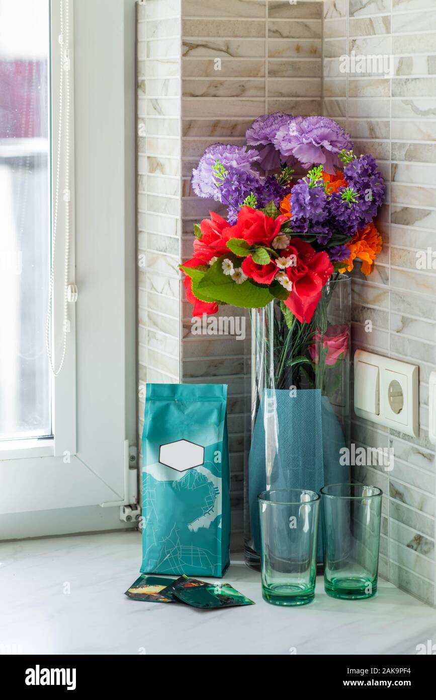 Nahaufnahme der Vase mit Blumen und zwei Gläser auf den weißen Fensterbank. Stockfoto