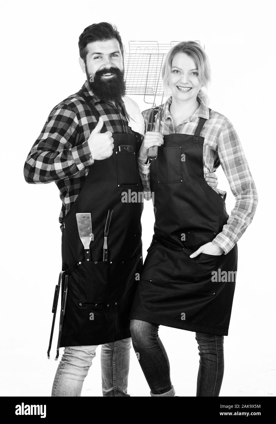 Die Qualität von Lebensmitteln. Wochenende mit der Familie. Man bärtige Hipster und Mädchen. Vorbereitung und Kulinarisches. Werkzeuge zum Braten von Fleisch. Paar in der Liebe halten Küchengeräte. Picknick Grill. Essen kochen Rezept. Stockfoto