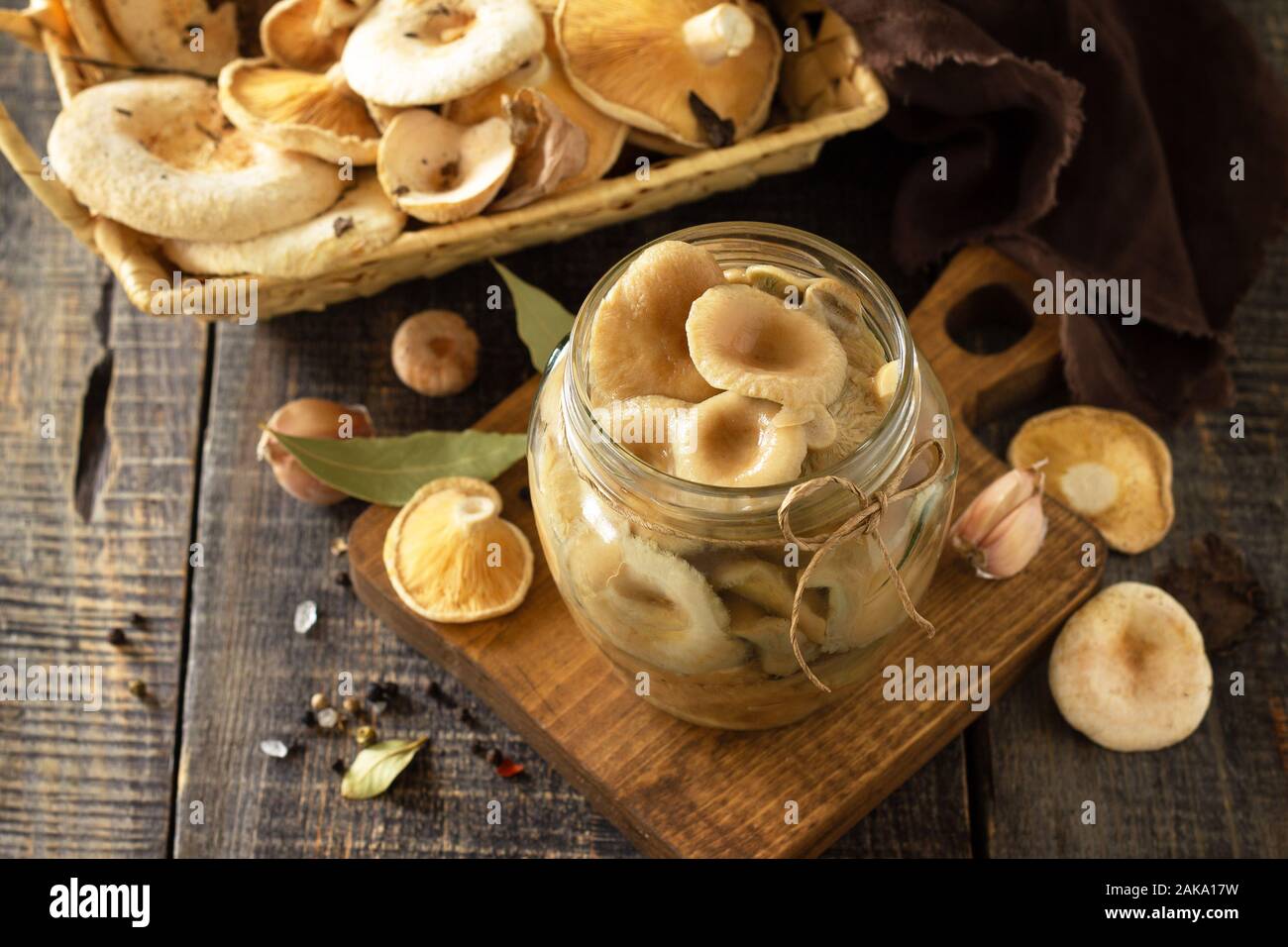 Pilz Bewahrung. Home Erhaltung der Produkte: Gläser mit eingelegte Pilze mit Gewürzen auf einem rustikalen Holztisch. Stockfoto