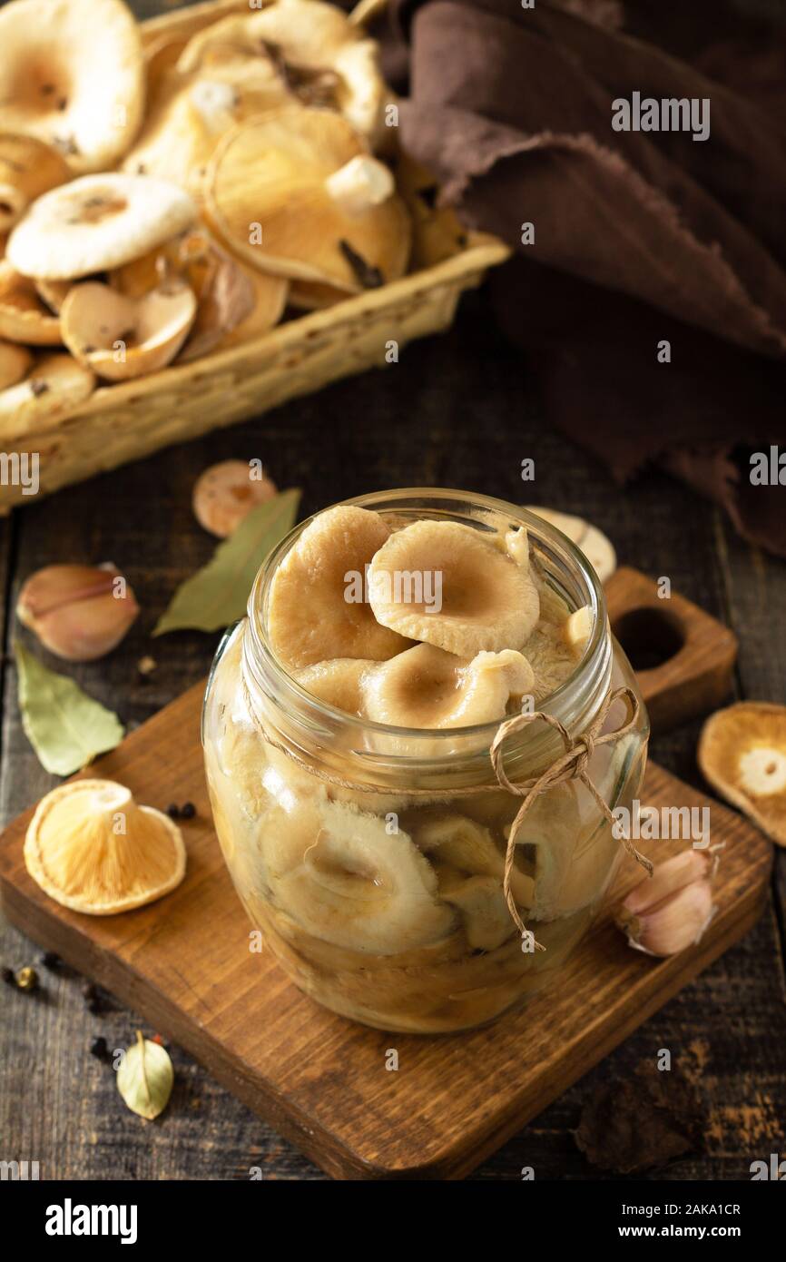 Pilz Bewahrung. Home Erhaltung der Produkte: Gläser mit eingelegte Pilze mit Gewürzen auf einem rustikalen Holztisch. Stockfoto