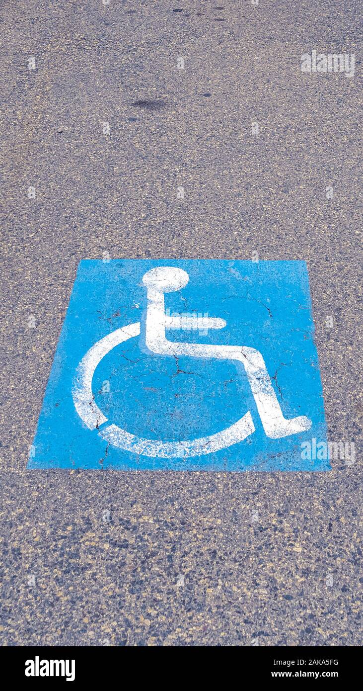 Vertikale Behinderte Symbol auf dem Asphalt an einem bewölkten Tag lackiert Stockfoto