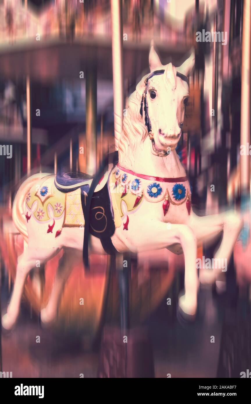 Vintage Karussell Pferd. Im antiken Stil geschnitzte Holz auf einem alten Amusement Merry go round, Bewegungsunschärfe. Stockfoto