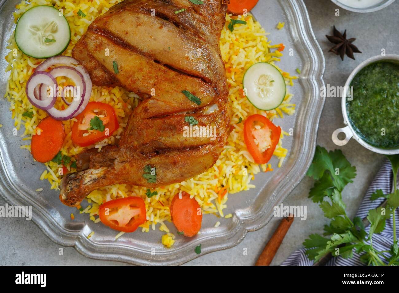 Huhn Kabsa/kuzhi Mandhi oder Mandi Biryani serviert mit Joghurt Minze Chutney Stockfoto