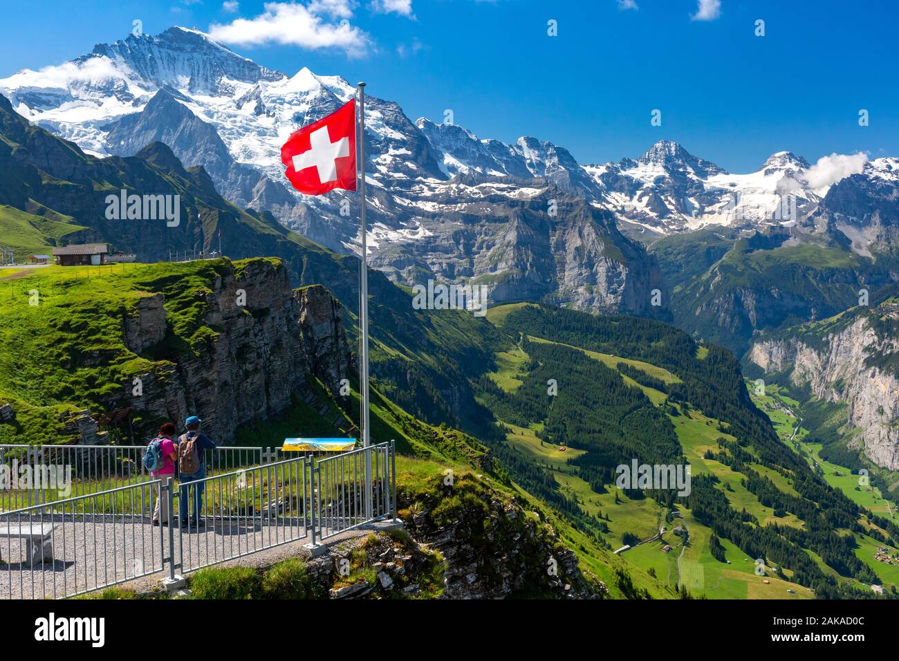 Schweizer Fahne winken und Touristen bewundern die Gipfel der Jungfrau auf Mannlichen Viewpoint, Berner Oberland Schweiz Stockfoto