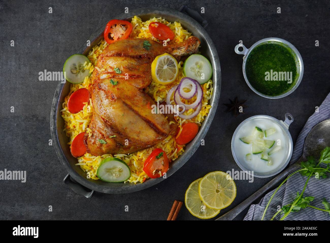 Huhn Kabsa/kuzhi Mandhi oder Mandi Biryani serviert mit Joghurt Minze Chutney Stockfoto