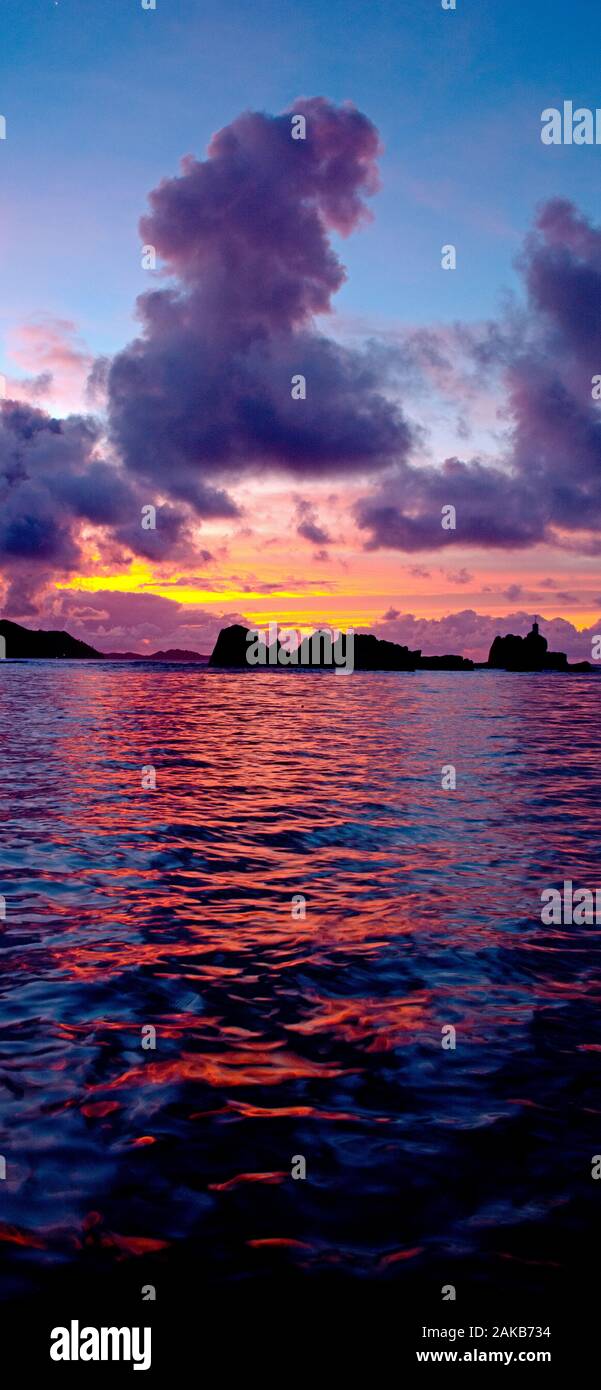 Marine mit Felsformationen unter Moody Himmel bei Sonnenuntergang Silhouette, La Digue, Seychellen Stockfoto
