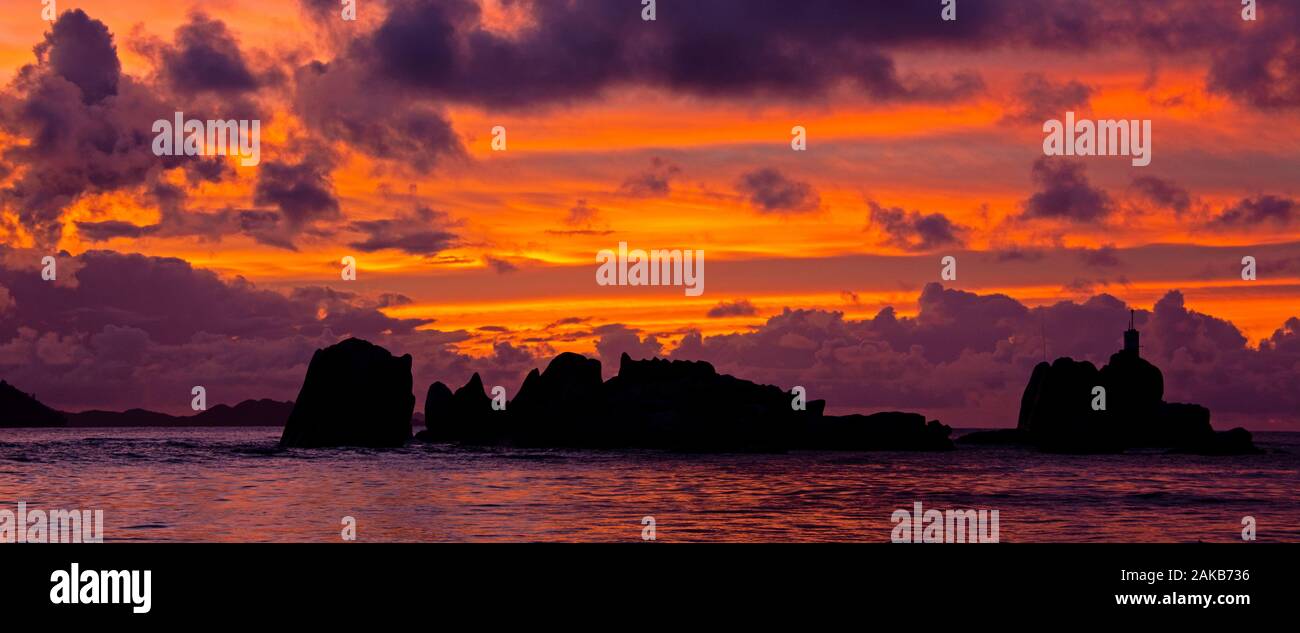 Marine mit Felsformationen unter Moody Himmel bei Sonnenuntergang Silhouette, La Digue, Seychellen Stockfoto