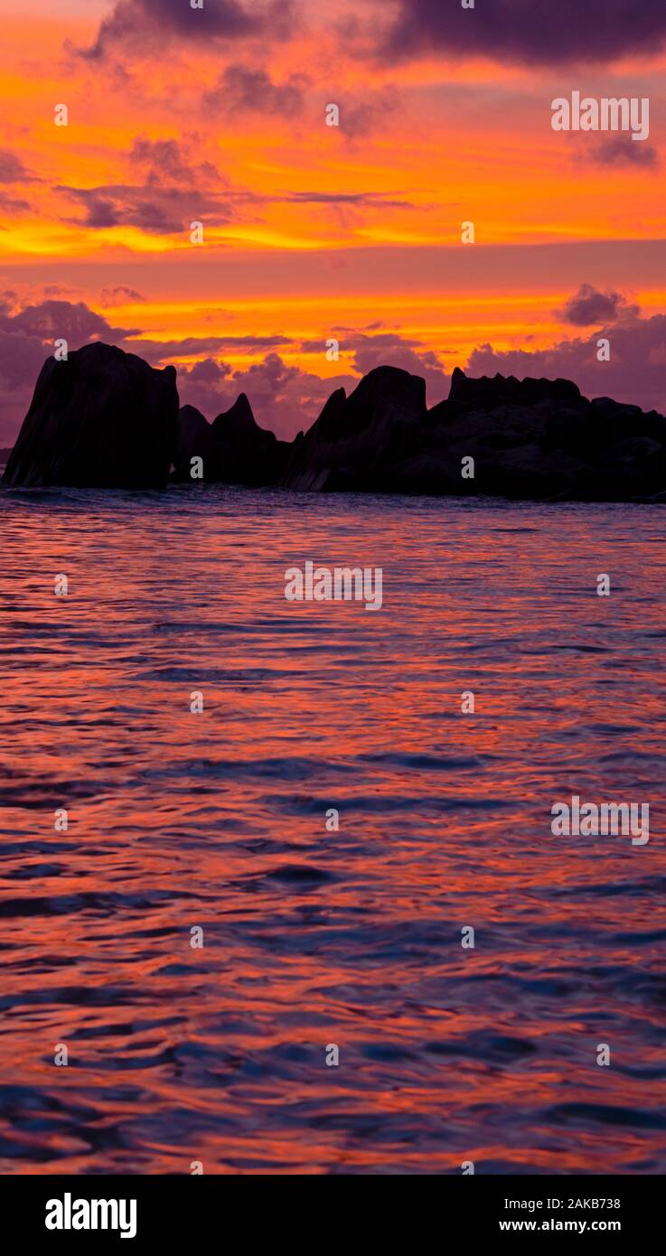 Marine mit Felsformationen unter Moody Himmel bei Sonnenuntergang Silhouette, La Digue, Seychellen Stockfoto