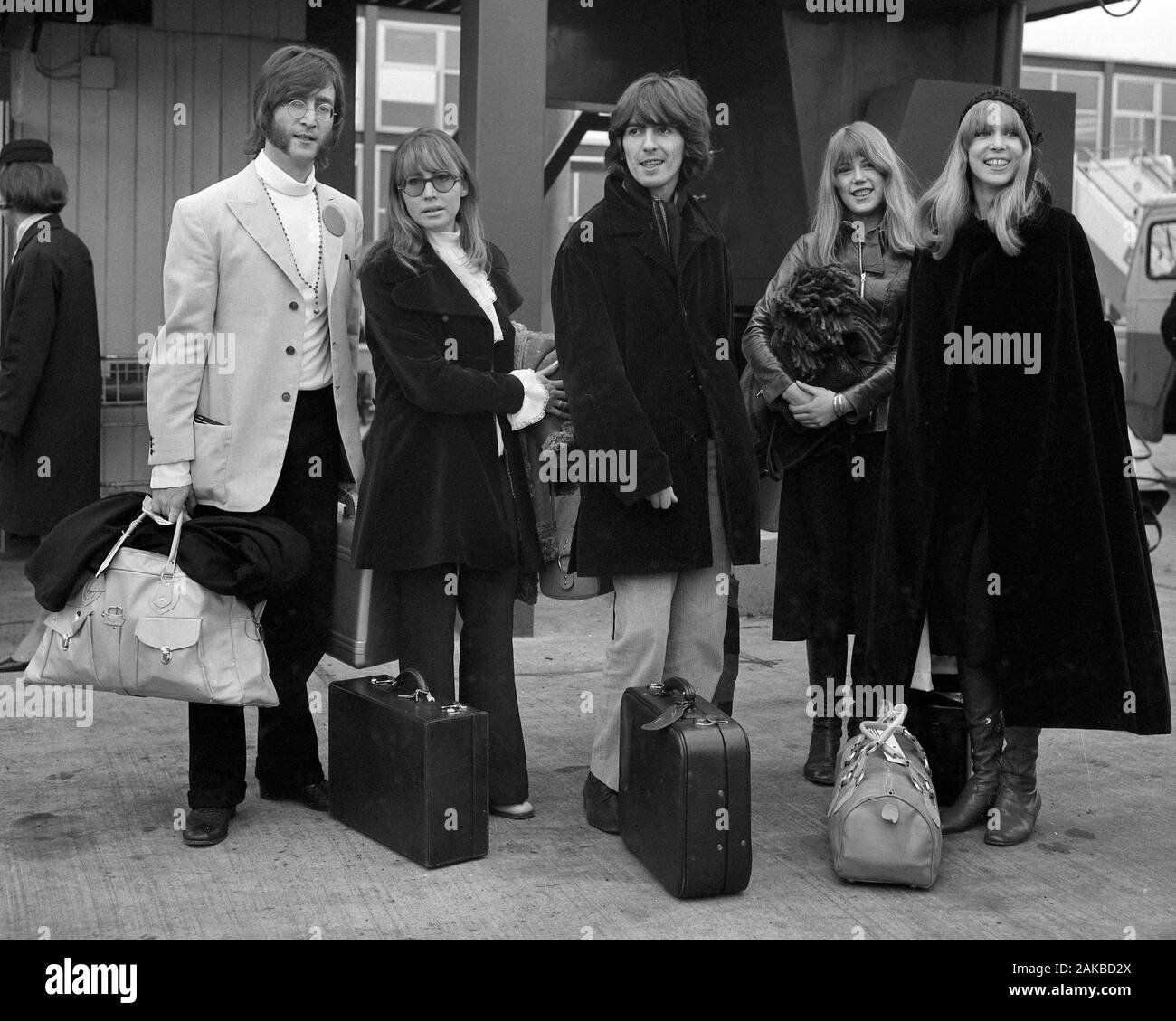 Beatles stars John Lennon (l) und George Harrison zusammen mit ihren Frauen, Cynthia Lennon (Zweite links) und Pattie Harrison (r), und Frau Harrison's Schwester Jenny Boyd am Flughafen Heathrow, London, vor dem Fliegen nach Indien. Stockfoto