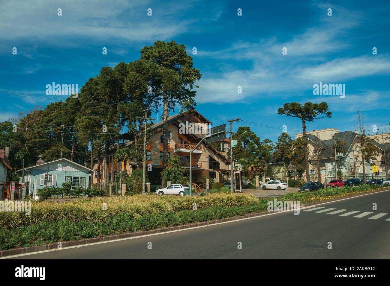 Häuser und Bäume auf einem leeren gepflasterte Straße an einem sonnigen Tag bei Gramado. Ein niedliches europäisch geprägten Stadt im südlichen Brasilien. Stockfoto