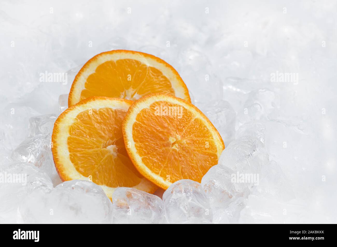 Frisches Orange im Hintergrund mit Eiswürfeln und Kopierbereich. Gesund 2020. Gesunde Ernährung. Gesundheit 2020 Stockfoto