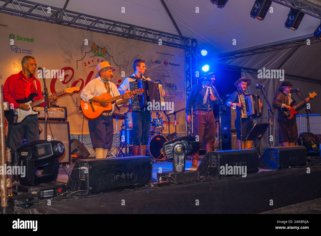 Musiker tragen typische Kleidung, traditionelle Lieder auf der Bühne eines folkloristischen Festival in Canela. Eine charmante kleine Stadt im Süden Brasiliens. Stockfoto