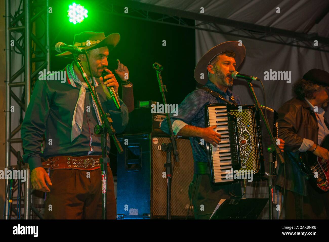 Musiker tragen typische Kleidung, traditionelle Lieder auf der Bühne eines folkloristischen Festival in Canela. Eine charmante kleine Stadt im Süden Brasiliens. Stockfoto