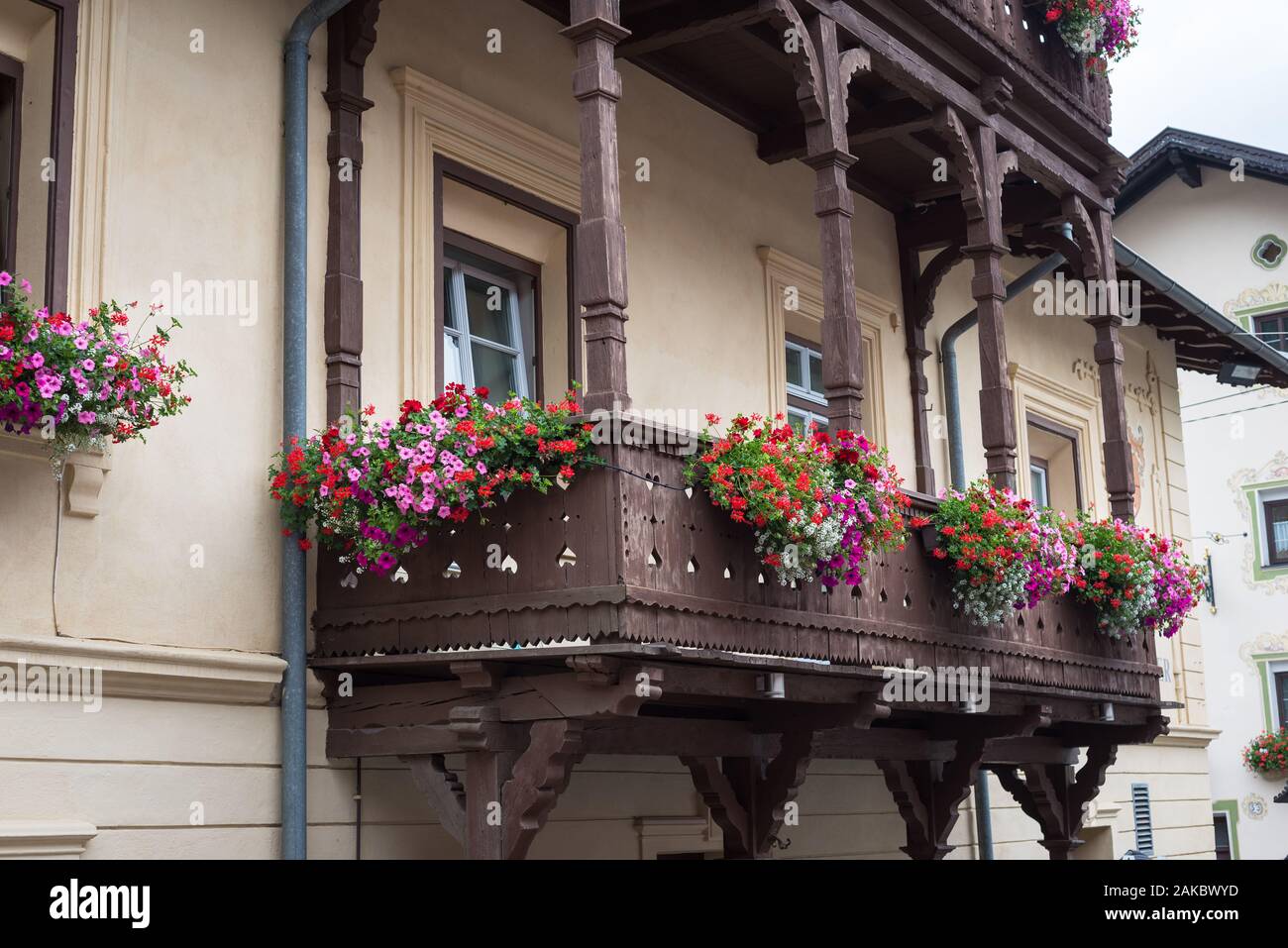Traditioneller Holzbalkon mit bunten Geranienblüten in Südtirol Stockfoto