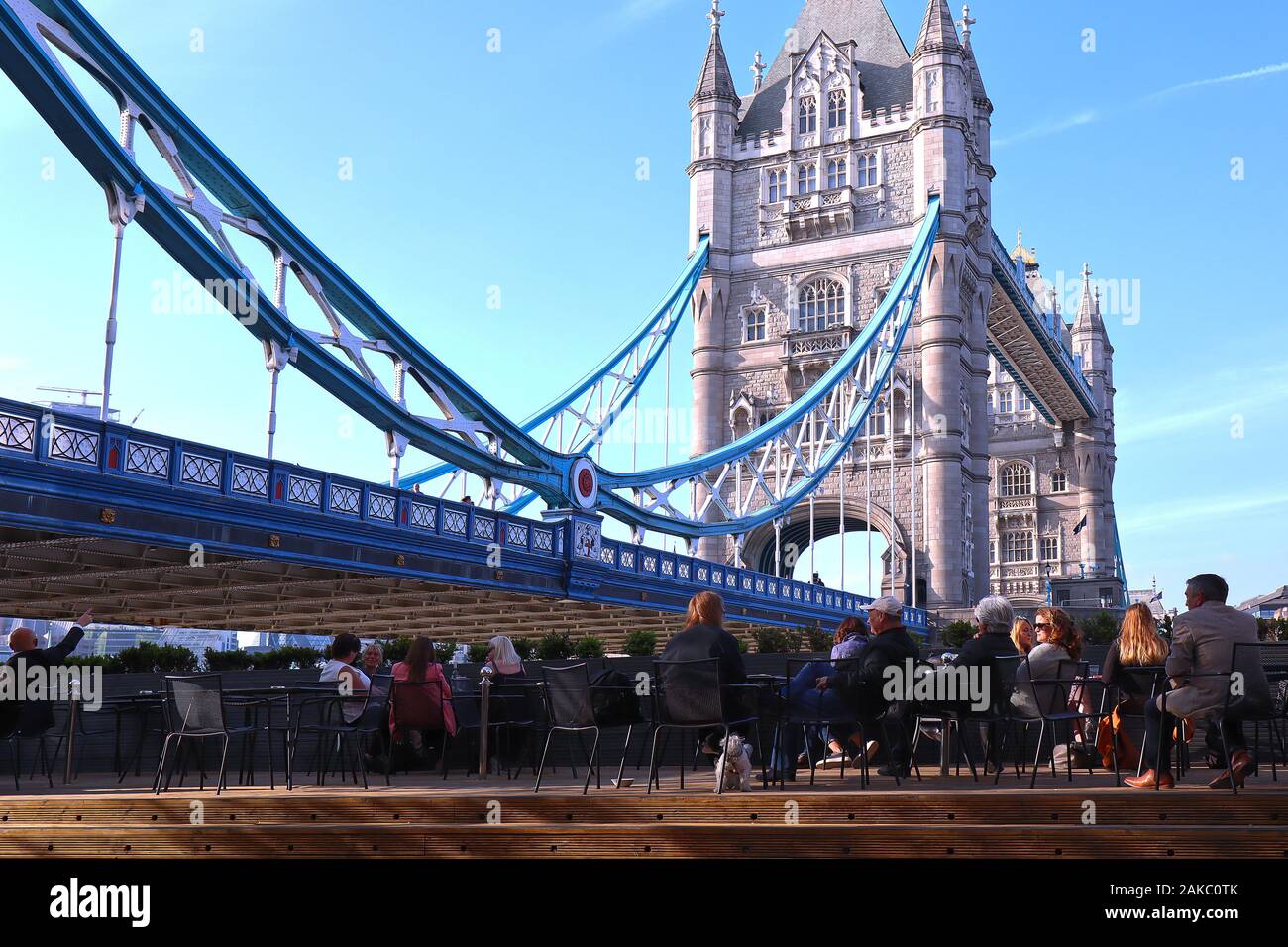 Menschen auf Stühlen entspannen und genießen den Blick auf die Tower Bridge in London sitzt Stockfoto