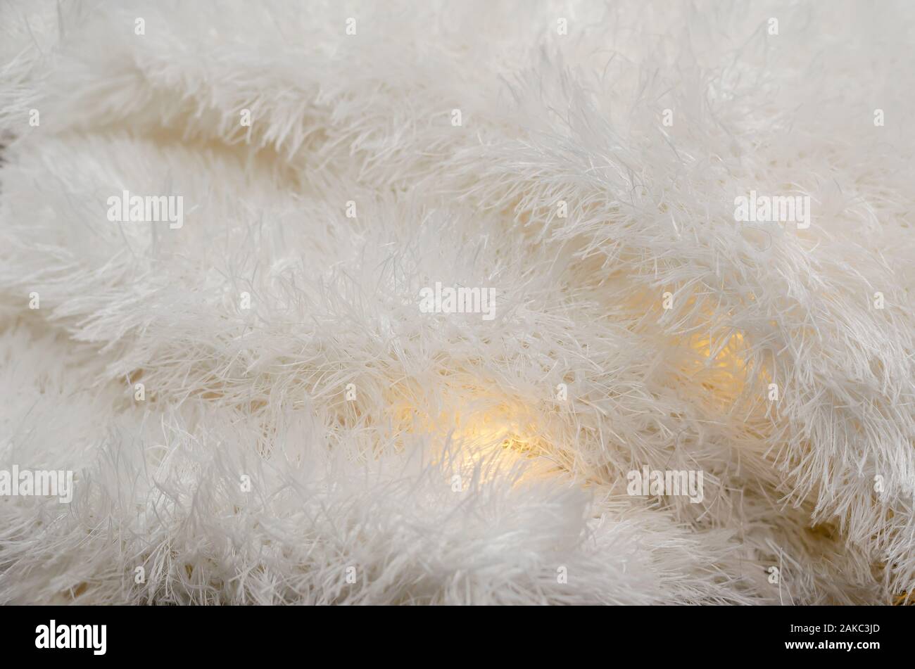 Weich und flauschig warmen Stoff. Leichte Stoff mit Lichtern zwischen die Falten. Zusammenfassung Hintergrund. Selektive konzentrieren. Stockfoto