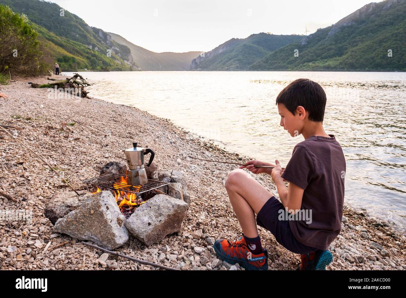 Serbien, Golubac, Clement kümmert sich um das Feuer für das Abendessen am Ufer der Donau Stockfoto