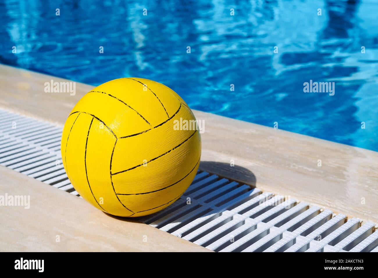 Sommer Spiele im Pool. Gelbe Kugel auf einem Hintergrund des blauen Wassers an einem sonnigen Resort Stockfoto