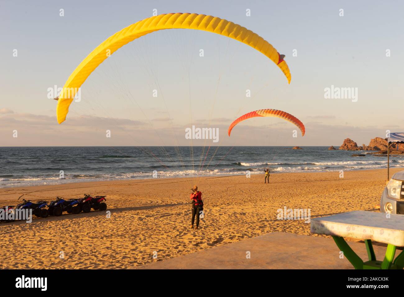 Ein Mann bereitet sich sein Fallschirm zu starten Paragliding am Strand von Legzira in die aufwinde von der Klippe Stockfoto