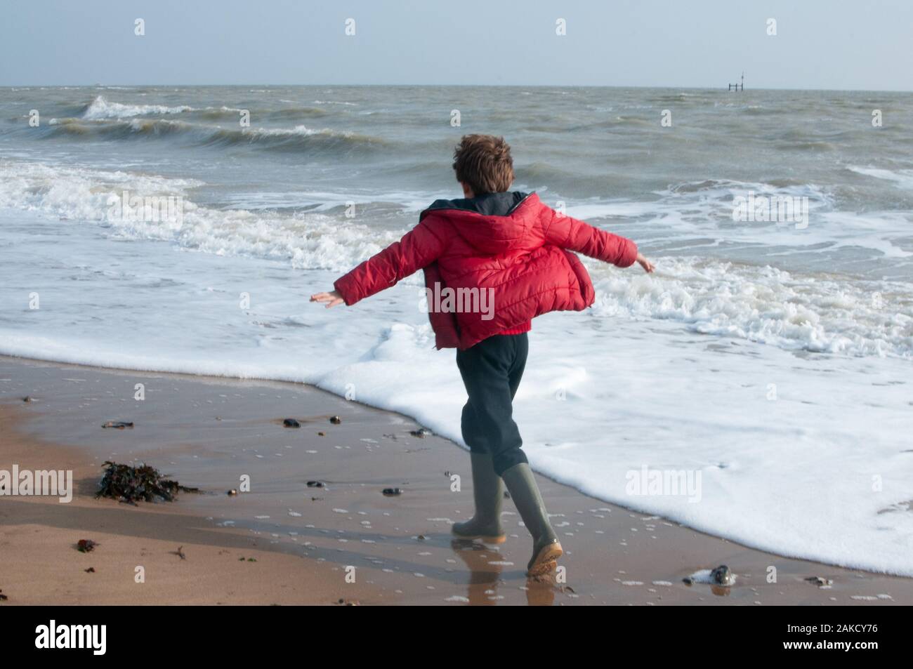 Junge zu Fuß am Strand Stockfoto