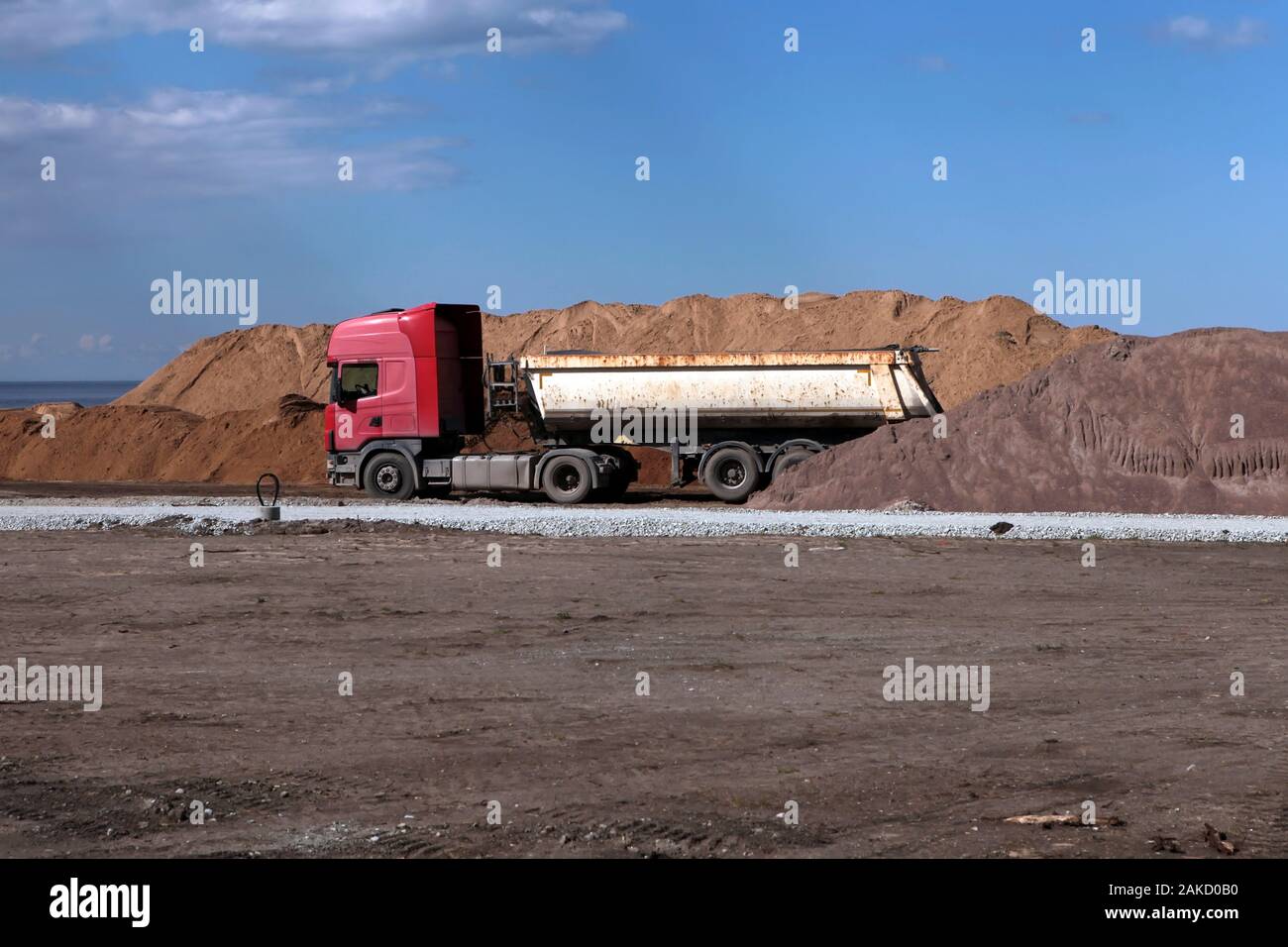 Alte Lkw in der Nähe von Sand Haufen an der Straße Baustelle. Große alte roadworking Kipper bau Konzept Stockfoto