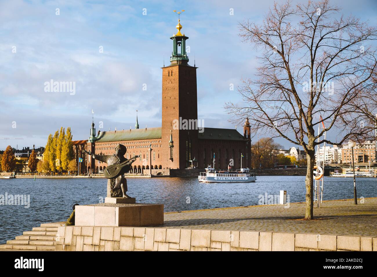Malerischer Blick auf berühmte Stockholmer Rathaus mit Djurgarden Fähre und Evert Taube Statue, Stockholm, Schweden, Skandinavien Stockfoto