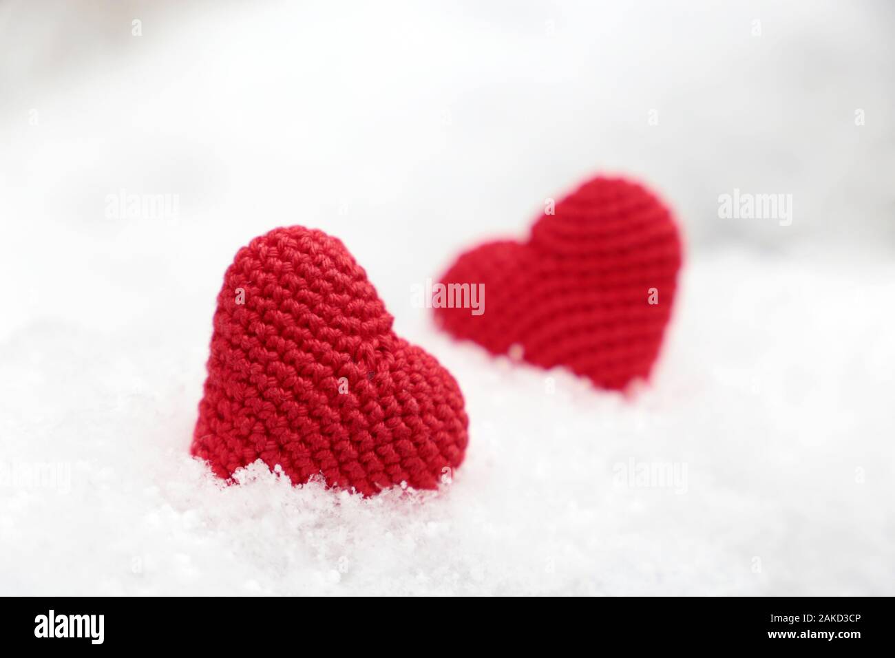 Liebe Herz, Valentinstag Karte, zwei Rote gestrickt Symbole der Leidenschaft in den Schnee. Hintergrund für romantische Veranstaltung, Feier oder Winter Wetter Stockfoto