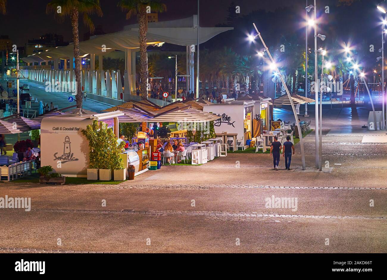 MALAGA, SPANIEN - 26. SEPTEMBER 2019: Am Abend Blick auf kleine Cafés und moderne Palmenhain von Überraschungen (El Palmeral de las Sorpresas) Promenade, stret Stockfoto